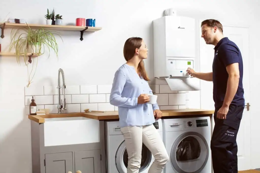 A Gas Safe registered engineer with a homeowner beside a boiler